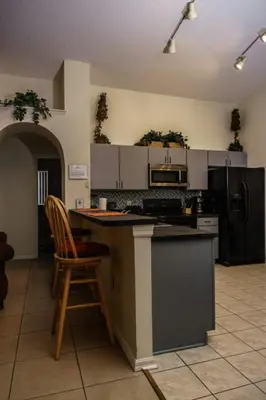 a kitchen with a counter and a chair in it at 4 Bed Villa - Eagle Pointe - Kissimmee in Kissimmee