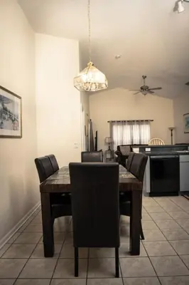 a dining room with a wooden table and chairs at 4 Bed Villa - Eagle Pointe - Kissimmee in Kissimmee