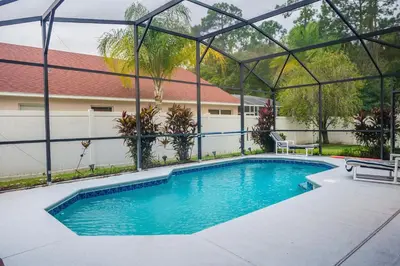 a swimming pool with a pergola next to a house at 4 Bed Villa - Eagle Pointe - Kissimmee in Kissimmee