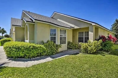 a yellow house with bushes in the yard at 4 Bedroom Villa - Indian Creek in Kissimmee