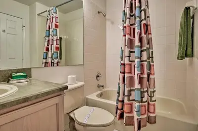 a bathroom with a toilet and a shower curtain at 4 Bedroom Villa - Indian Creek in Kissimmee