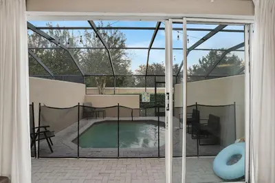a view of a swimming pool through a sliding glass door at Casa 3Q Windsor Hills c/ Piscina Perto da Disney in Orlando