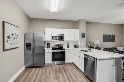 a kitchen with stainless steel appliances and white cabinets at Casa 3Q Windsor Hills c/ Piscina Perto da Disney in Orlando