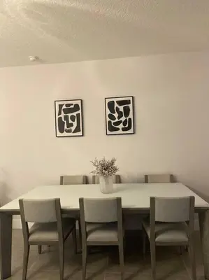 a dining room table with chairs and a vase with flowers at beautiful home in Kissimmee
