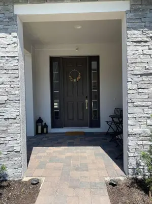 a front door of a house with a stone wall at beautiful home in Kissimmee