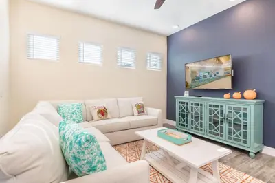 a living room with a white couch and a table at Pleasant Cottage Near Disney With Margaritaville Resort & Island H20 Waterpark Access - 2972Sr in Orlando