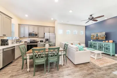 a kitchen and living room with a table and chairs at Pleasant Cottage Near Disney With Margaritaville Resort & Island H20 Waterpark Access - 2972Sr in Orlando