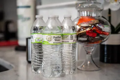 three bottles of water sitting next to a wine glass at Apartment in Florida near Universal and Intern. Dr in Orlando