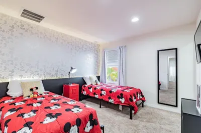 a bedroom with two beds and a red bedspread with cows on it at Casa 3Q Resort + Jacuzzi Perto Disney in Kissimmee