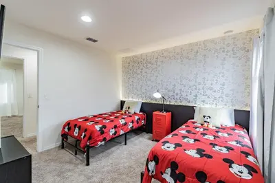 a bedroom with two beds and a red comforter at Casa 3Q Resort + Jacuzzi Perto Disney in Kissimmee