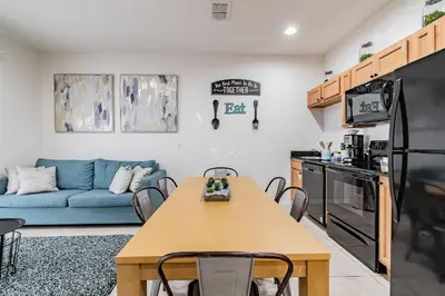 a living room with a table and a blue couch at Casa 3Q Resort + Jacuzzi Perto Disney in Kissimmee