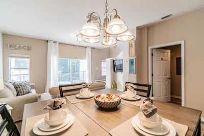 a dining room and living room with a dining table at Casa 3Q Bella Vida c Piscina Próx Disney e Walmart in Kissimmee