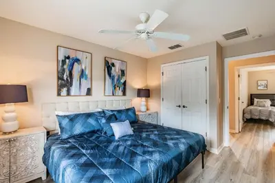 a bedroom with a blue bed and a ceiling fan at Casa 3Q Bella Vida c Piscina Próx Disney e Walmart in Kissimmee