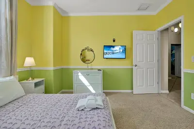a bedroom with a bed and a mirror on the wall at Entire home w/ Private Pool,Gated Near Disney in Orlando