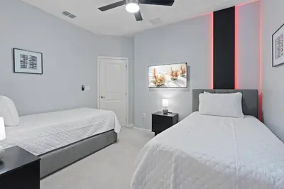 a bedroom with two beds and a red and white wall at New Home 8 Bedrooms At Bella Vida in Kissimmee