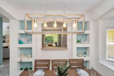 a dining room with a table and a chandelier at Family Villa with Private Pool Game Room & Themed Rooms in Kissimmee
