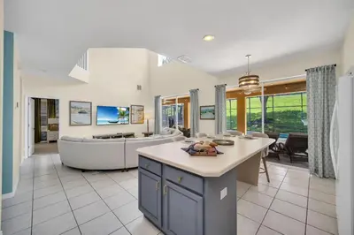 a kitchen and living room with a couch and a table at Family Villa with Private Pool Game Room & Themed Rooms in Kissimmee