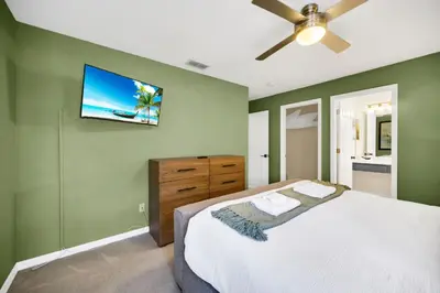 a bedroom with a bed and a flat screen tv on the wall at Family Villa with Private Pool Game Room & Themed Rooms in Kissimmee