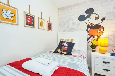 a bedroom with a mickey mouse mural on the wall at Family Villa with Private Pool Game Room & Themed Rooms in Kissimmee