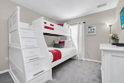 a bedroom with a white bunk bed with white drawers at Family Oasis Cozy Retreat with Bunk Room in Kissimmee