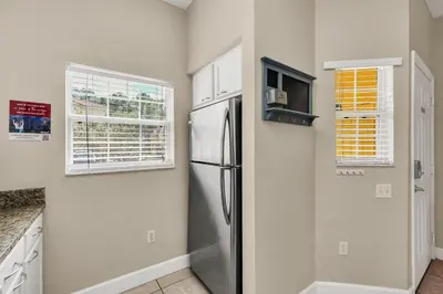 a kitchen with a refrigerator and a window at Family Oasis Cozy Retreat with Bunk Room in Kissimmee