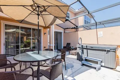 a patio with a table and chairs and a grill at 2 Suítes, Jacuzzi priv. perto da DISNEY in Kissimmee