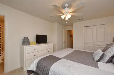 a bedroom with a bed and a ceiling fan at Casa 4Q c/ Piscina Priv. e Vista Lago in Kissimmee