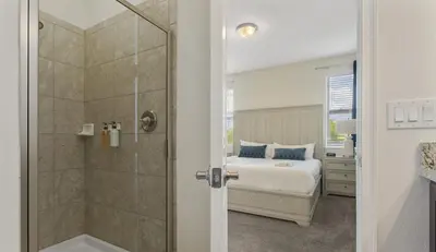 a bedroom with a bed and a glass shower at Casa c/ Piscina, Sala de Jogos e 6 Suítes in Orlando