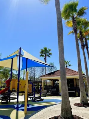 a playground with palm trees in front of a building at Ideal 3 BR Resort Villa with Laundry in Kissimmee