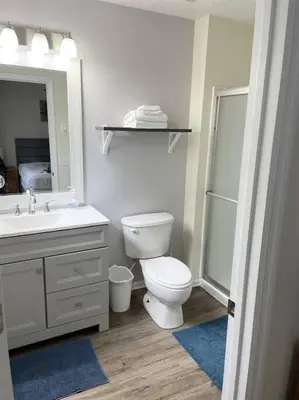 a bathroom with a toilet and a sink and a mirror at Ideal 3 BR Resort Villa with Laundry in Kissimmee