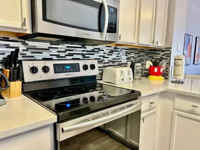 a kitchen with a stove and a microwave at 7660 - 3Q/3B Casa em Resort *10min DISNEY* in Orlando