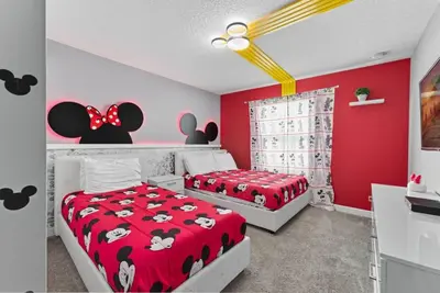 two beds in a bedroom with red and white walls at Casa de Luxo em Storey Lake Resort in Kissimmee
