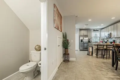a bathroom with a toilet and a kitchen at 3Q/2.5B *Ótima Localização* in Kissimmee