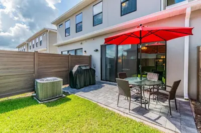 a patio with a table with a red umbrella at 3Q/2.5B *Ótima Localização* in Kissimmee