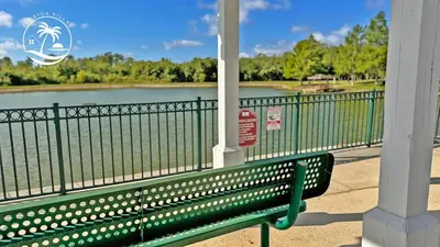 a green bench sitting next to a body of water at Deluxe Villas Resort at Seven Dwrafs - Close to Disney in Kissimmee