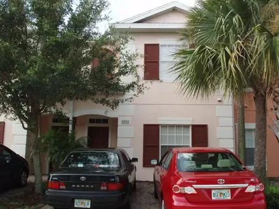 two cars parked in front of a house at Four Bedroom Villa in Coral Cay in Kissimmee