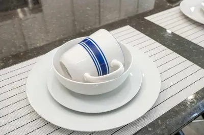 a cup and saucer on a plate on a table at 4BR Lakefront - Themed Rooms - Pool & BBQ! in Kissimmee