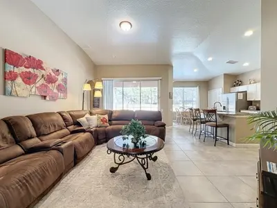 a living room with a brown couch and a table at 4 Bed in Windsor Palms Resort - Steps to Disney villa in Kissimmee