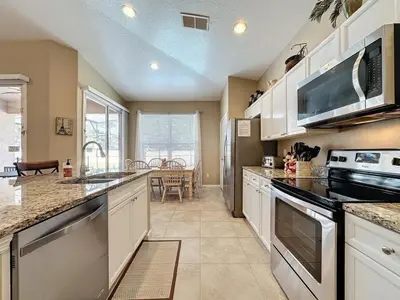 a kitchen with white cabinets and a stove top oven at 4 Bed in Windsor Palms Resort - Steps to Disney villa in Kissimmee