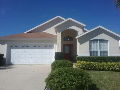 a large white house with a garage at 2551 Oneida Grantham! in Kissimmee