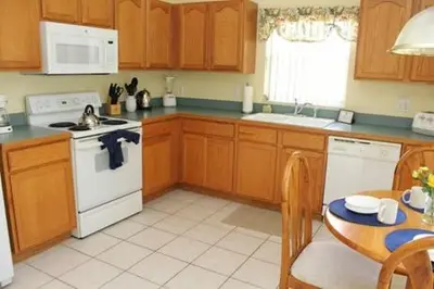a kitchen with wooden cabinets and a table and a stove at 8056 Indian Creek Blvd in Kissimmee