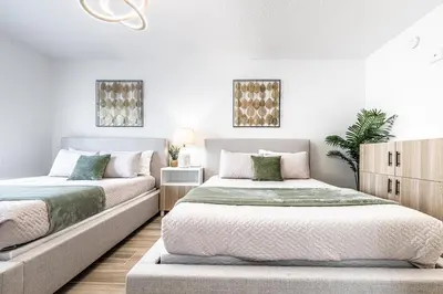 two beds in a bedroom with white walls at Apartment - near Epic Universe and Universal, free parking in Orlando