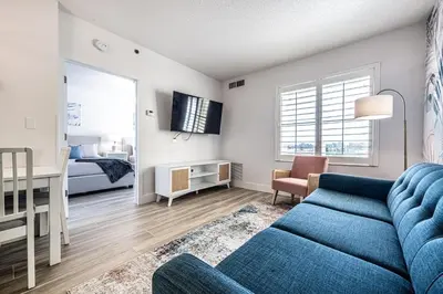 a living room with a blue couch and a bedroom at One bedroom unit near Epic Universe and Universal, free parking in Orlando