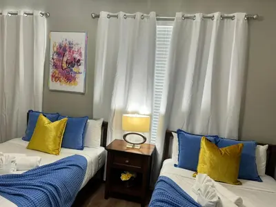 a room with two beds with blue and yellow pillows at P42 New Townhouse at Vista Cay Walking distance to CCCO in Orlando