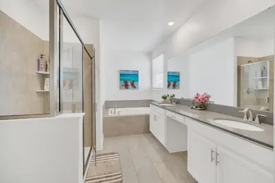 a white bathroom with a sink and a shower at Spotless 6 bedroom Villa - Storey Lake - Hot tub - Free Water Park - 15 Mins to Disney in Kissimmee