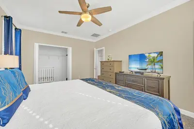 a bedroom with a bed and a ceiling fan at Spotless 6 bedroom Villa - Storey Lake - Hot tub - Free Water Park - 15 Mins to Disney in Kissimmee