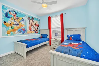 a bedroom with two beds and a painting on the wall at Spotless 6 bedroom Villa - Storey Lake - Hot tub - Free Water Park - 15 Mins to Disney in Kissimmee