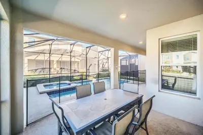 a dining room with a table and a large window at Spotless 6 bedroom Villa - Storey Lake - Hot tub - Free Water Park - 15 Mins to Disney in Kissimmee
