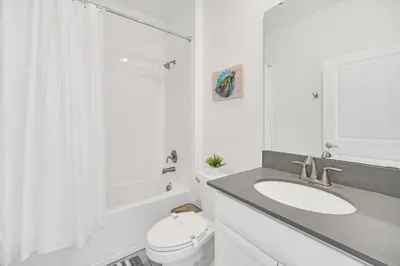 a white bathroom with a sink and a toilet at Spotless 6 bedroom Villa - Storey Lake - Hot tub - Free Water Park - 15 Mins to Disney in Kissimmee