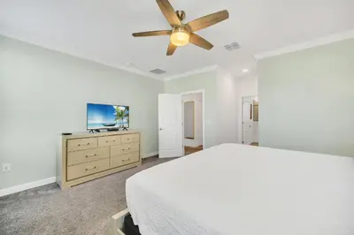 a bedroom with a bed and a ceiling fan at Spotless 6 bedroom Villa - Storey Lake - Hot tub - Free Water Park - 15 Mins to Disney in Kissimmee